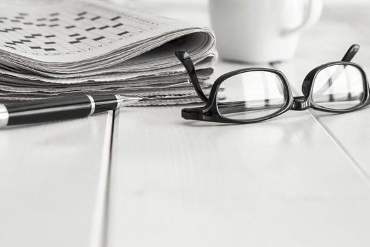 Stack of newspapers with eyeglasses and coffee