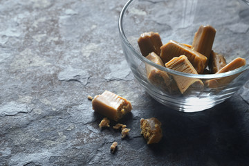 Toffee in the glass bowl on the stone table