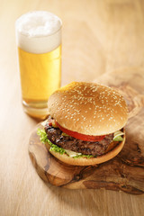 fresh juicy burger with lager beer on oak table