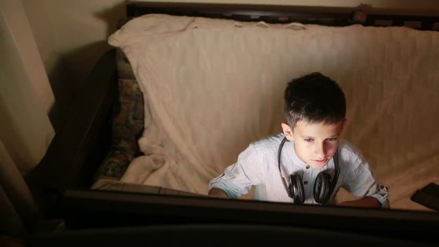 Teen boy plays games on the computer at night. Online Games