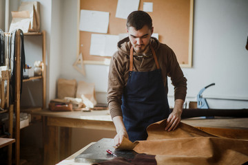 Master a man in an apron marks the skin to the article. Small bu