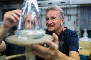 Glassblower and a colleague examining glassware