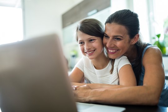 Mother and daughter using laptop and tablet 