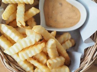French fries in a bowl on a wooden background
