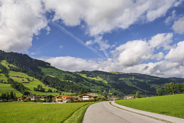 Fototapeta na wymiar Country road in Brixental Valley in Tirolean Alps, Austria, popular summer and winter location for tourism .