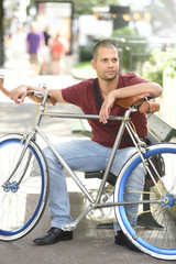 Obraz premium Man with bicycle sitting on park bench