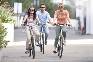 People on vacation riding bicycles in town street