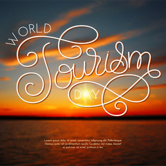 World tourism day hand lettering on blurred photo background