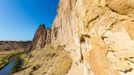 The path between the rock and the river. The sheer rock walls. Beautiful landscape of yellow sharp cliffs. Smith Rock state park, Oregon