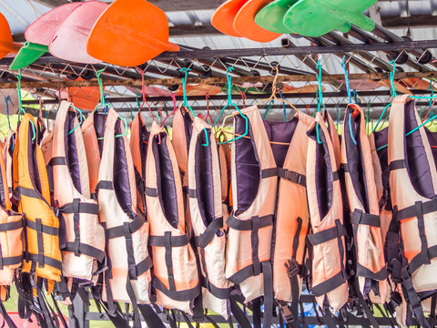 Orange life jackets and colorful paddles for services
