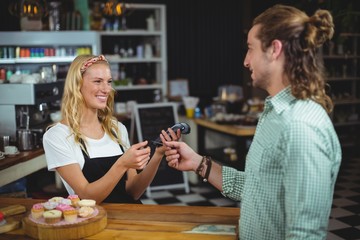 Fototapeta premium Happy customer giving credit card to waitress
