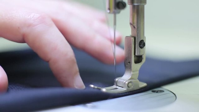 Man working with sewing machine close up.