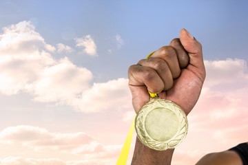 Fototapeta na wymiar hand holding medal over sky background