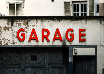 Old abandoned garage with red sign