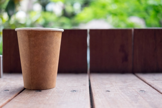 brown paper cup on wood table