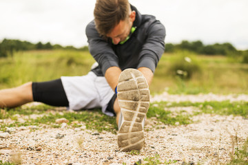 Young handsome man doing stretching and exercises outdoors