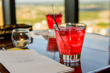 Bright Red Cocktail with Ice, Straw and Pamphlet