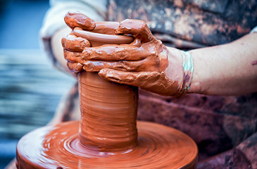 hands of a potter, creating an earthen jar on the circle
