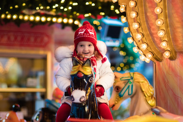 Obraz na płótnie Canvas Child riding carousel on Christmas market