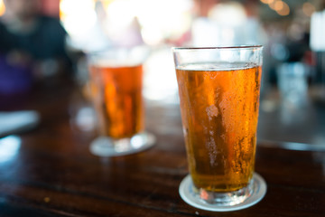 Two frosty cold beers on a bar waiting to be drunk