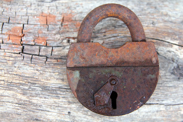 Old rusty lock on a wooden background
