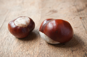 Obraz premium marrons sur table en vieux bois - fruit du marronnier d'inde - Aesculus hippocastanum