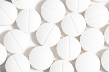 Close up of scored white round tablet pills opioid pain killers isolated on white background