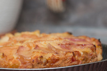 Apple pie on the plate. Golden crust. The interior of the kitchen.