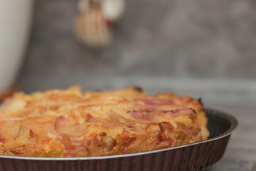 Apple pie on the plate. Golden crust. The interior of the kitchen.