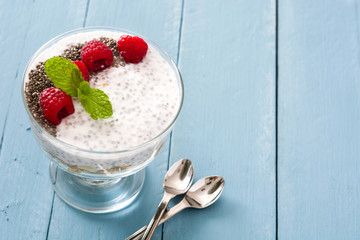 Chia yogurt with raspberries on blue wooden table

