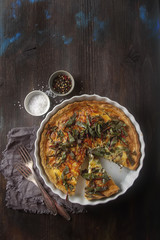 Traditional French cake. quiche with chard in white. Dark wood b