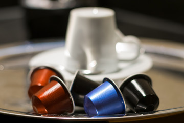 Obraz na płótnie Canvas Coffee Capsules with cup in the background