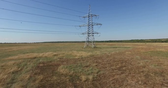 AERIAL: Flying up the high voltage electricity tower and power lines. Aerial drone shot. 4K 30fps