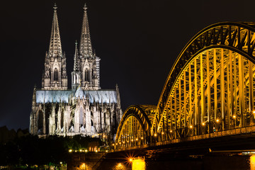 Illuminated Cologne Cathedral at night with Hohenzollern Bridge