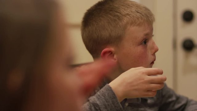 Close up on a little boy eating dinner with his family