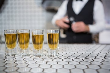 Glasses of whisky on bar counter