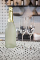 Champagne bottle and champagne flute on bar counter