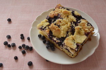 Grandma's homemade yeast cake made with frozen berries and crumble on white plate
