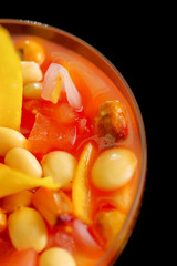 Traditional ecuadorian cold tomato based dish with chochos, onions and banana chips, elegant restaurant presentation