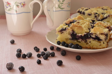 Grandma's homemade yeast cake made with frozen berries and crumble on white plate with two lovely...