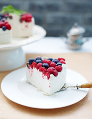 Cheesecake, cream mousse cake with fresh berries on a white plate Selective focus