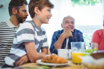 Multi-generation family sitting at breakfast table