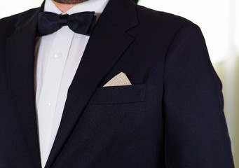 Closeup man's chest area wearing formal suit and bowtie, men getting dressed concept
