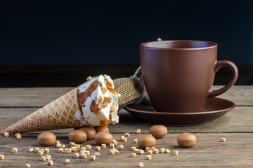 Ice cream cone on wooden table with cup