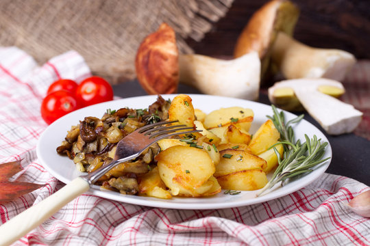 Fried potatoes with cepes in a plate on the table