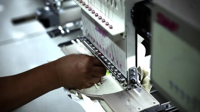 An industrial embroidery machine needs to be adjusted.