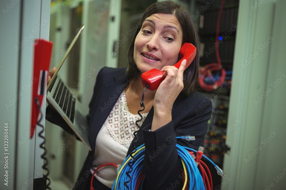 Poster Technician talking on phone while analyzing server