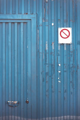 Prohibitory sign on old metal blue door
