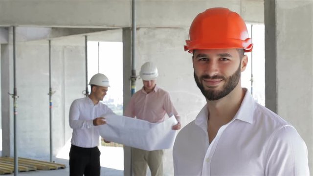 Construction engineer poses at the building under construction