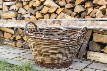 Old wicker basket, is laid next to the wood in a row